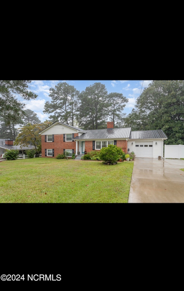 view of front of property featuring a front lawn, an outdoor structure, and a garage