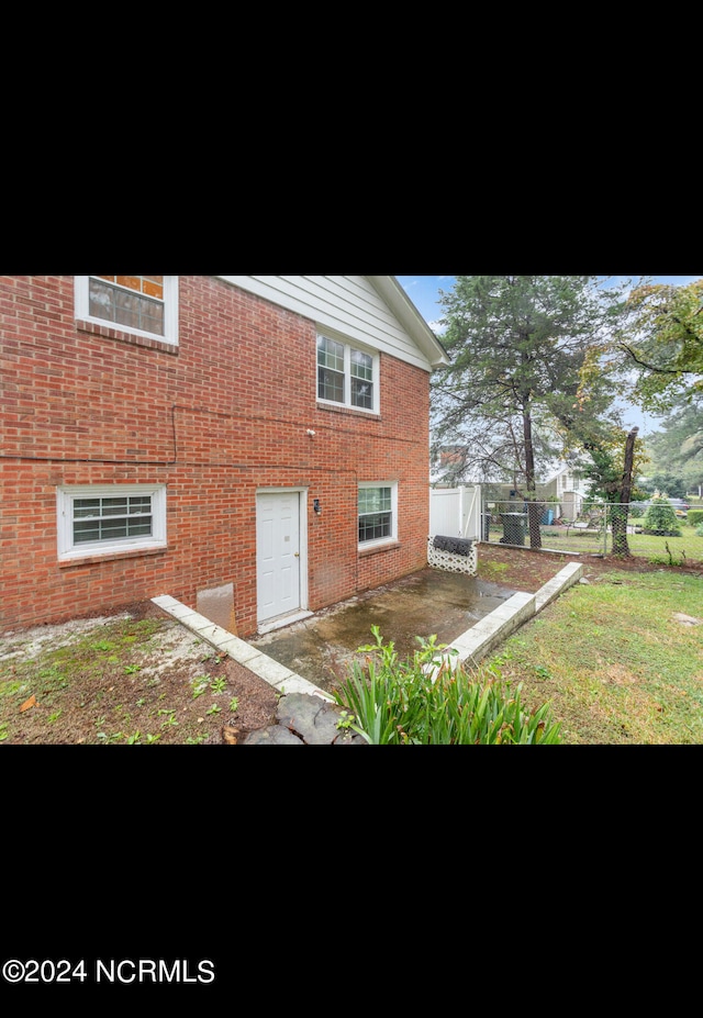 view of property exterior with a patio and a lawn