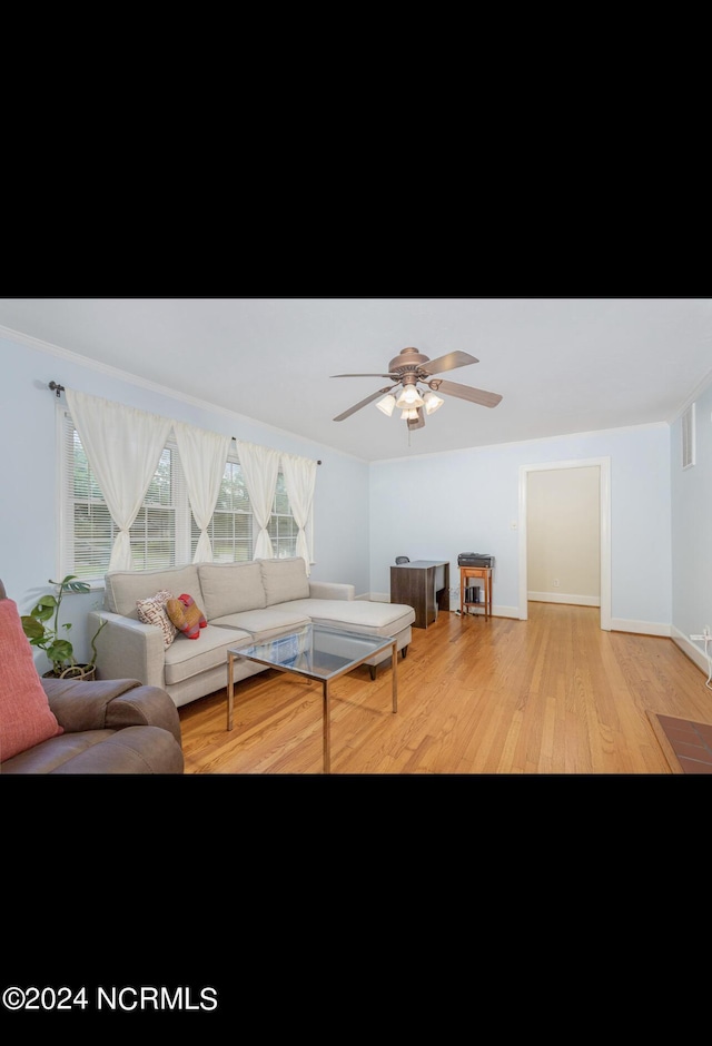 living area featuring baseboards, visible vents, light wood-style flooring, and ceiling fan