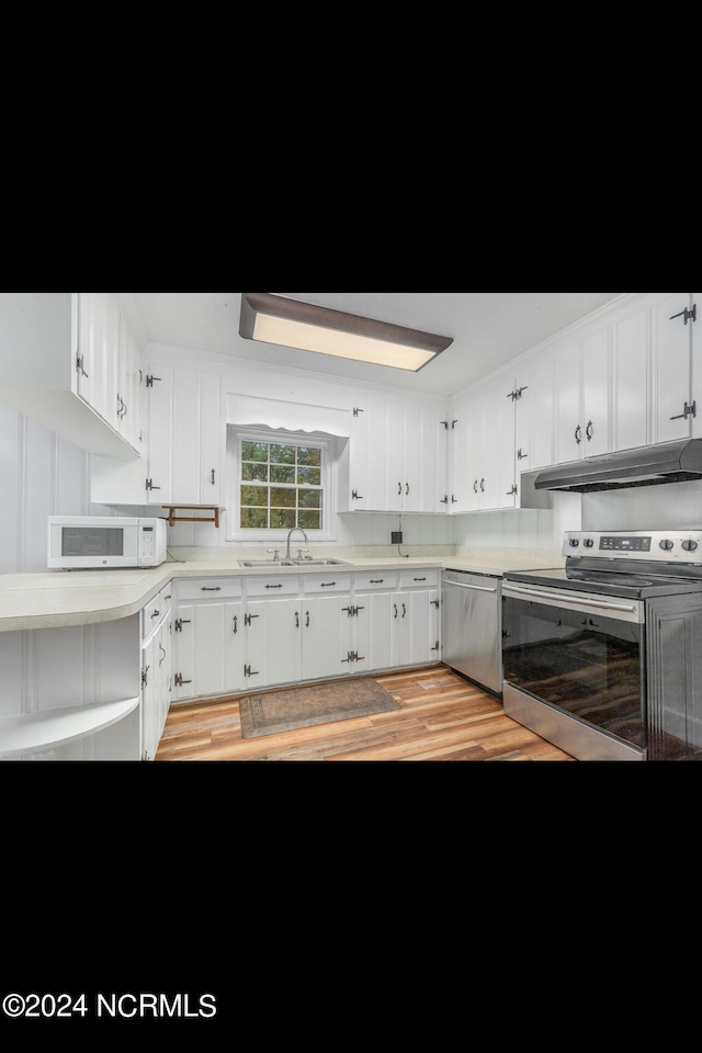 kitchen with stainless steel appliances, white cabinets, light wood-type flooring, and sink