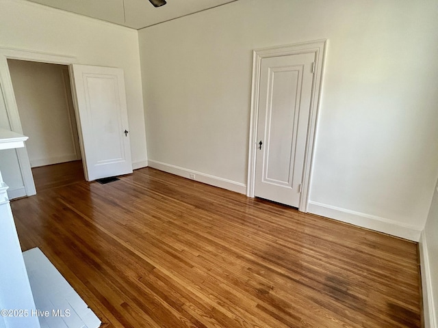 unfurnished room featuring baseboards, ceiling fan, and wood finished floors