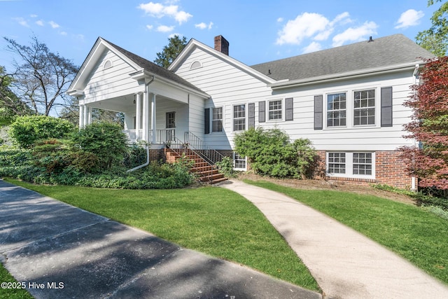 view of front of home featuring a chimney and a front lawn