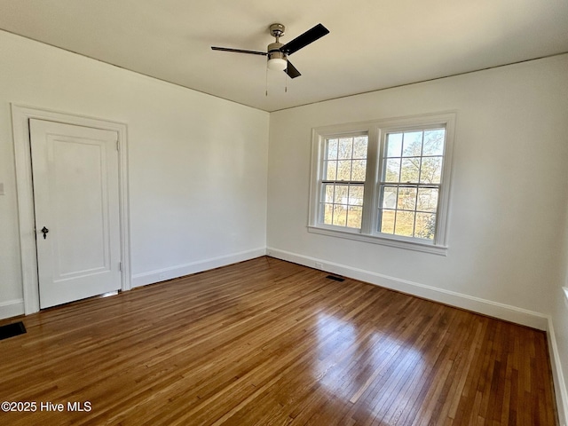 empty room with dark hardwood / wood-style floors and ceiling fan