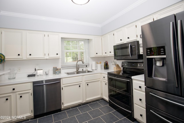 kitchen with crown molding, a sink, stainless steel appliances, white cabinetry, and dark tile patterned flooring