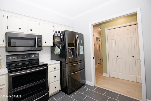 kitchen featuring light countertops, appliances with stainless steel finishes, ornamental molding, and white cabinets