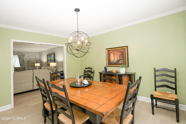 dining area with baseboards, ornamental molding, light wood-type flooring, and a notable chandelier