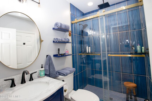 bathroom with vanity, a stall shower, and toilet