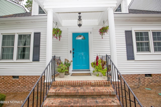 entrance to property featuring a shingled roof and crawl space
