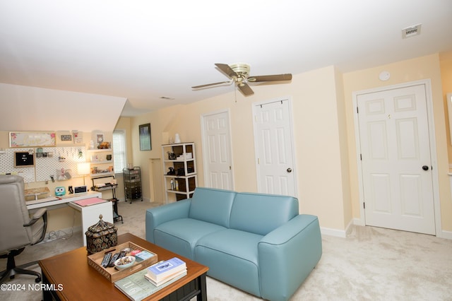 living area with baseboards, visible vents, a ceiling fan, and light colored carpet