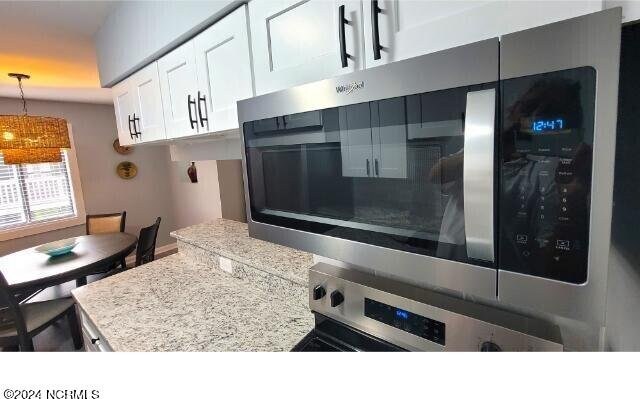 10166 Beach Dr SW Unit 5306, Calabash, NC 28467 - kitchen featuring appliances with stainless steel finishes, white cabinets, pendant lighting, and light countertops