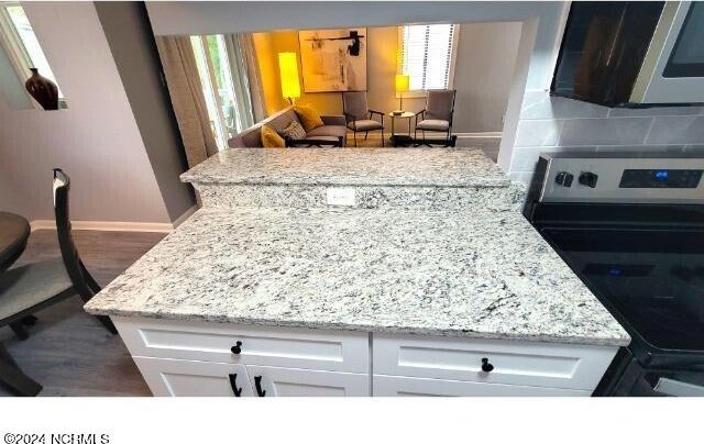 10166 Beach Dr SW Unit 5306, Calabash, NC 28467 - kitchen with electric stove, stainless steel microwave, white cabinetry, and backsplash