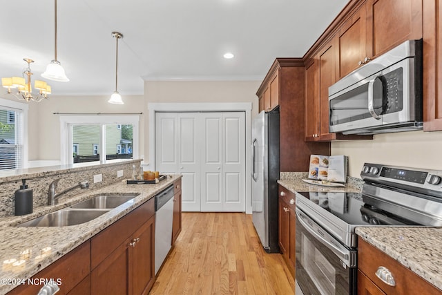 kitchen featuring light hardwood / wood-style floors, sink, crown molding, appliances with stainless steel finishes, and decorative light fixtures