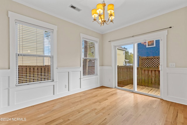 interior space featuring a notable chandelier, hardwood / wood-style flooring, and crown molding