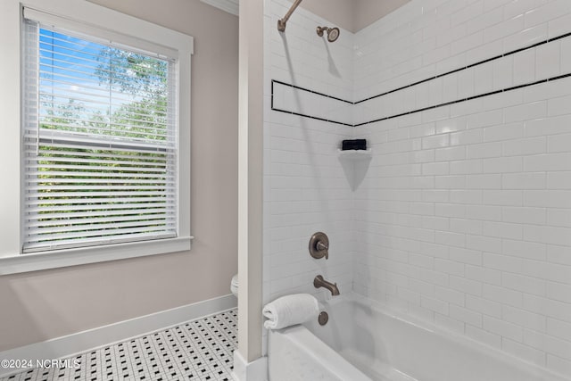 bathroom featuring tiled shower / bath combo, tile patterned floors, a healthy amount of sunlight, and toilet