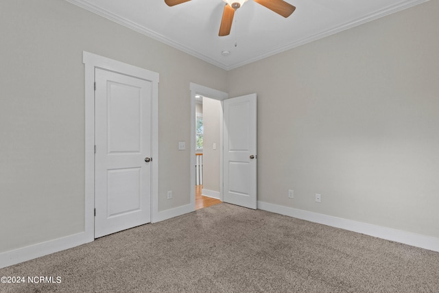 unfurnished bedroom featuring ornamental molding, carpet flooring, and ceiling fan