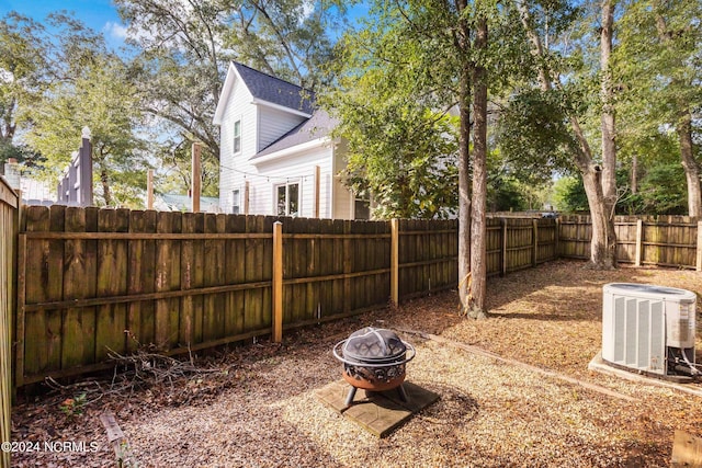 view of yard featuring central AC unit and a fire pit