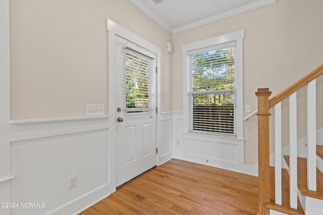 entryway featuring crown molding, a healthy amount of sunlight, and light hardwood / wood-style flooring