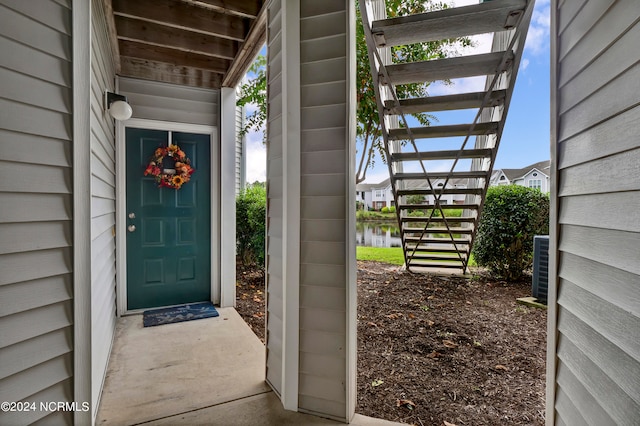 view of exterior entry featuring a pergola and a water view