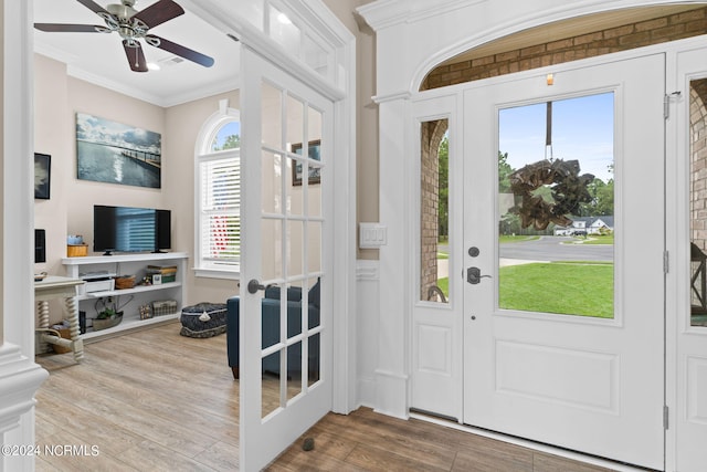 foyer entrance featuring a healthy amount of sunlight, crown molding, ceiling fan, and light hardwood / wood-style flooring