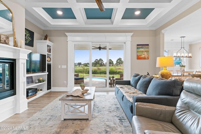 living room with ceiling fan, ornamental molding, hardwood / wood-style floors, and coffered ceiling