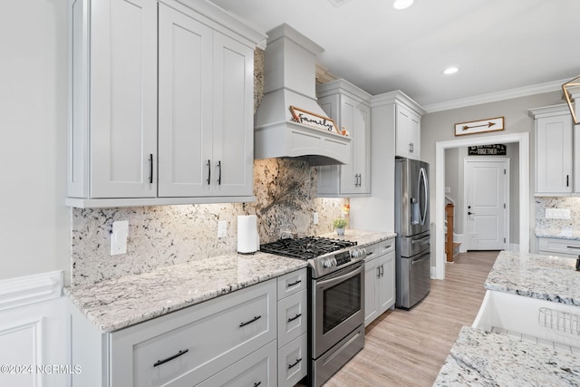 kitchen featuring light hardwood / wood-style floors, stainless steel appliances, backsplash, crown molding, and premium range hood