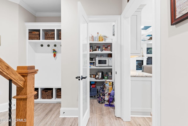 interior space with light wood-type flooring and ornamental molding