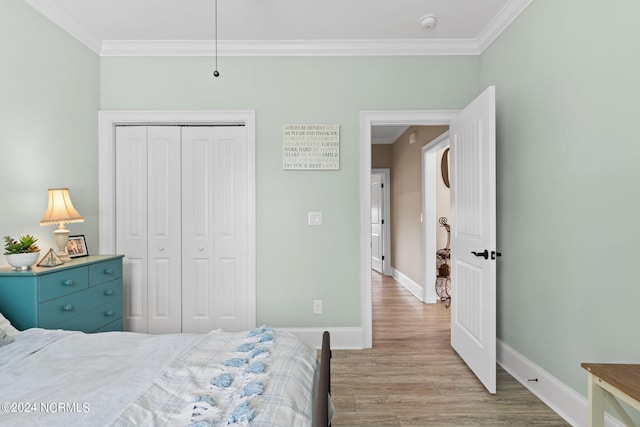 bedroom featuring ornamental molding, a closet, and light hardwood / wood-style floors