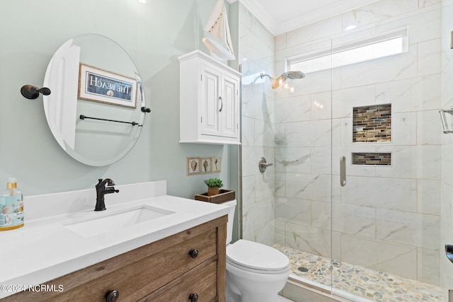 bathroom featuring ornamental molding, vanity, toilet, and a shower with door