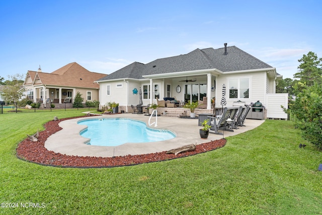 exterior space with ceiling fan, a diving board, a patio area, an outdoor living space, and a lawn