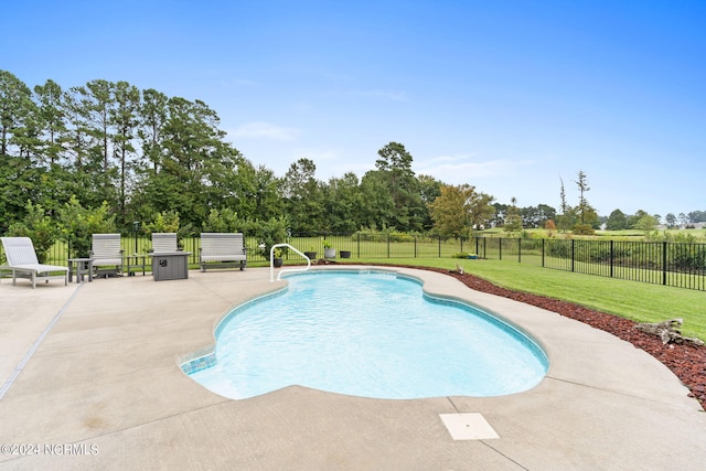 view of swimming pool featuring a lawn and a patio area