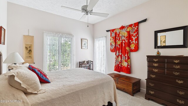 carpeted bedroom featuring a textured ceiling and ceiling fan