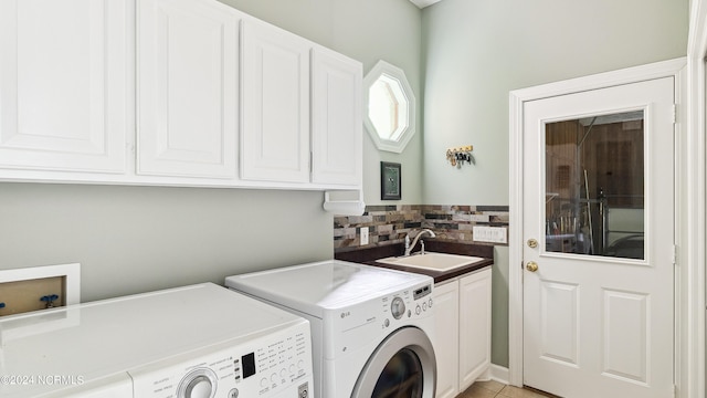 washroom featuring washer and clothes dryer, cabinets, sink, and light tile patterned floors