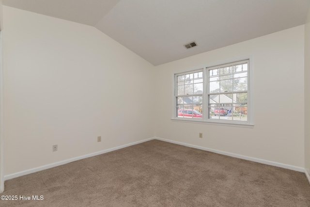 carpeted spare room featuring lofted ceiling