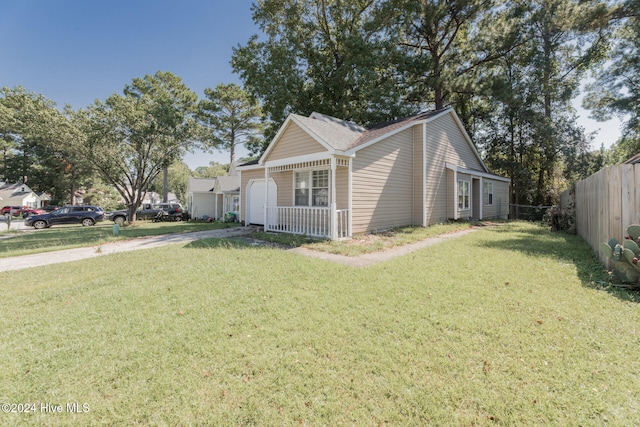 view of side of home with a lawn and covered porch