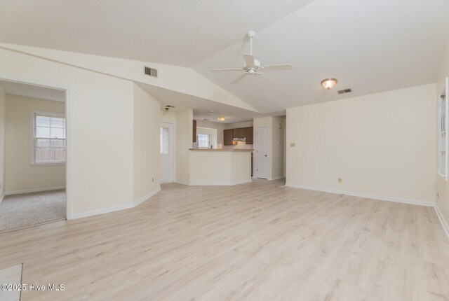 unfurnished living room featuring light wood-type flooring, ceiling fan, and lofted ceiling