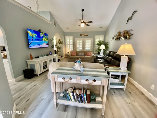 living room featuring light hardwood / wood-style flooring, ceiling fan, and high vaulted ceiling