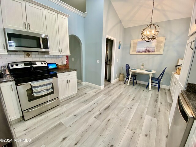 kitchen featuring pendant lighting, backsplash, a chandelier, stainless steel appliances, and light hardwood / wood-style floors