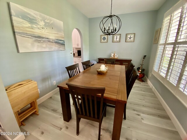 dining room with a notable chandelier and light wood-type flooring