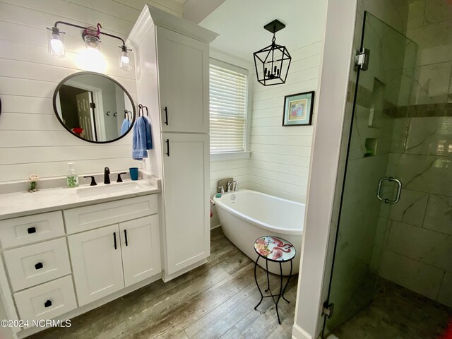 bathroom with wooden walls, vanity, plus walk in shower, and hardwood / wood-style flooring