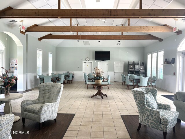 tiled dining area featuring a healthy amount of sunlight, beam ceiling, and high vaulted ceiling