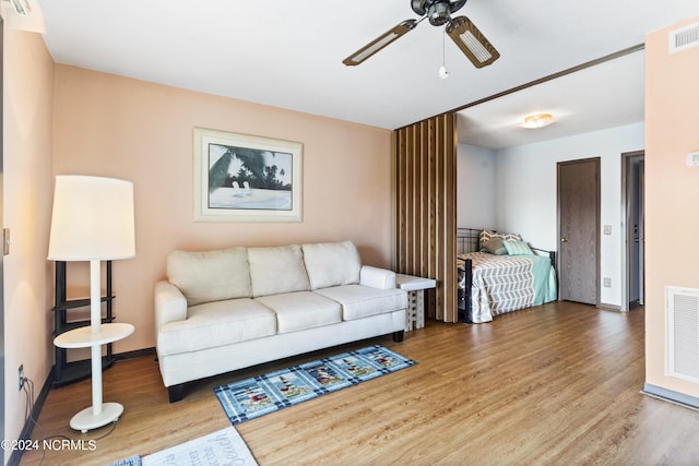 living room featuring wood-type flooring and ceiling fan