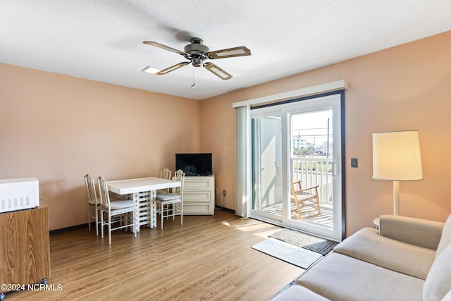 interior space featuring ceiling fan, light hardwood / wood-style floors, and a textured ceiling