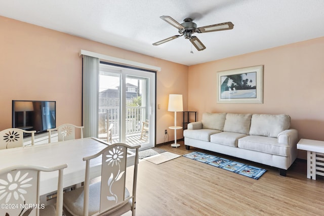 living room featuring ceiling fan, light hardwood / wood-style floors, and a textured ceiling