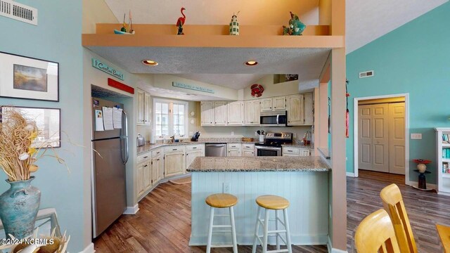 kitchen featuring sink, stainless steel appliances, a textured ceiling, and light hardwood / wood-style floors