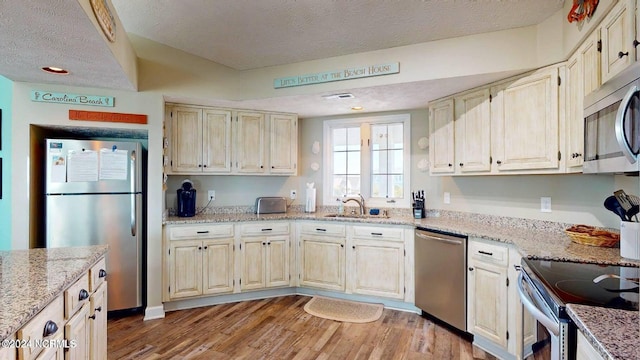 1514 Carolina Beach Ave N Unit 1 & 2, Carolina Beach, NC 28428 - kitchen with appliances with stainless steel finishes, a sink, light wood-style floors, a textured ceiling, and light stone counters