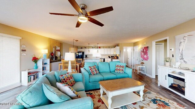 living room with wood-type flooring and ceiling fan