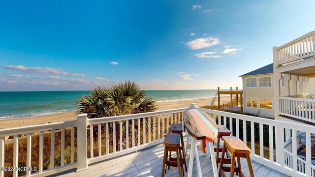 deck featuring a beach view and a water view