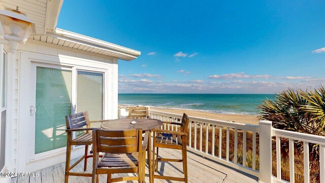 balcony with a deck with water view and a beach view