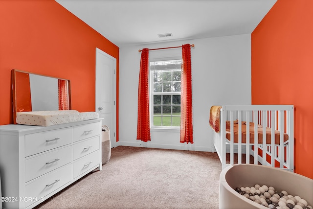 carpeted bedroom with a nursery area