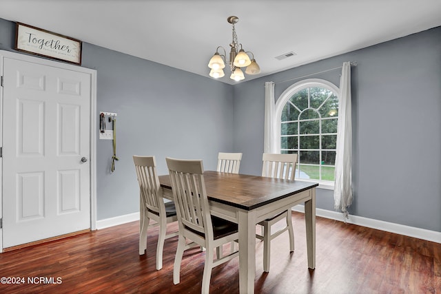 dining area with an inviting chandelier and dark hardwood / wood-style flooring